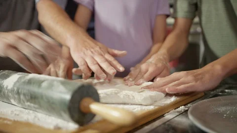 All hands crowding around homemade pizza dough in kitchen Stock Footage 123733526