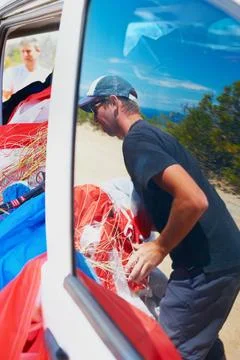 All packed and ready to go. a man packing his paragliding equipment into a van. 스톡 사진