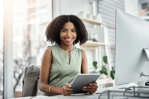 All the right tech to get her work tasks completed. a young businesswoman using Foto stock