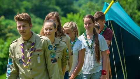 All scouts are walking in a straight line including a boy with a flag Stock Footage 108536701
