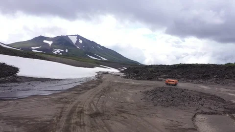 The All-Terrain Vehicle Is Going Through Lava Field And Glacier. Drone Video. Stock Footage 128770115