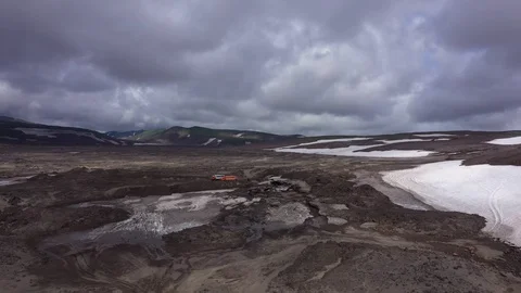 The All-Terrain Vehicle Is Going Through Lava Fields And Glacier. Drone Video. Stock Footage 128777259