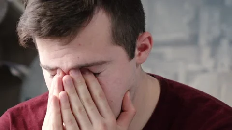 An allergic man sneezes while sitting in the house Vídeo Stock 132866378
