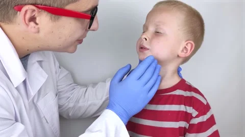 An allergist or dermatologist examines red spots on a child’s face. The boy suff Stock Footage 134704073