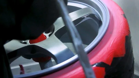   Alloy Wheels Being Primed Before Spray Painted by a Mechanic at a Garage. Stock Footage 106678258