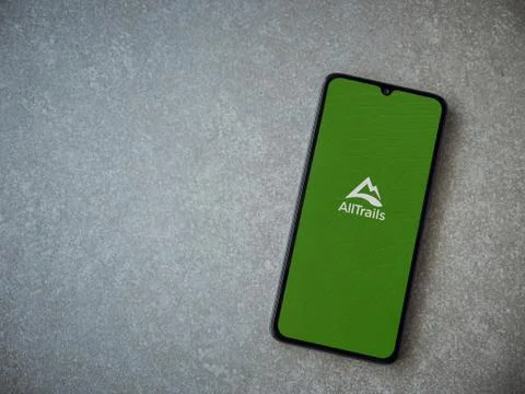 AllTrails app launch screen with logo on the display of a black mobile smartp Stock Photos