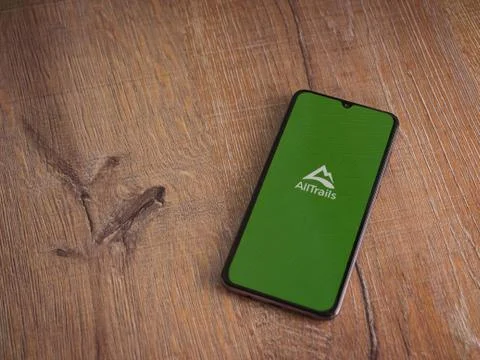 AllTrails app launch screen with logo on the display of a black mobile smartp Stock Photos