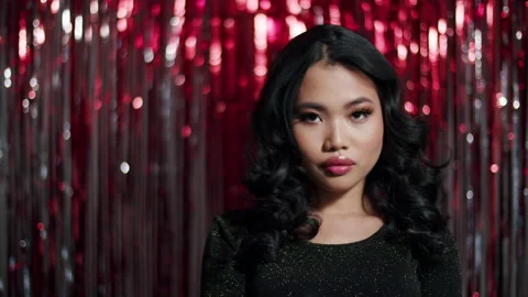 Alluring asian woman posing to a camera over red shiny background. 動画素材 224229719