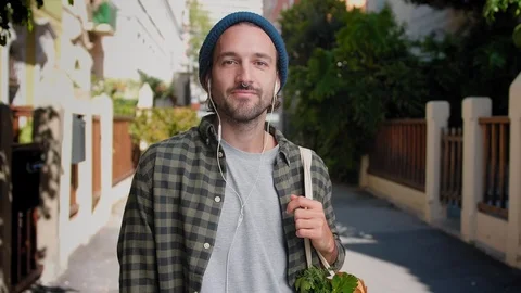 Alluring bearded man joyfully listening music with headphones in the middle of Stock Footage 111071459