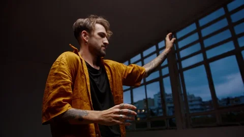 Alluring Caucasian man dancing modern freestyle choreography at dark dance Stock Footage 109365914