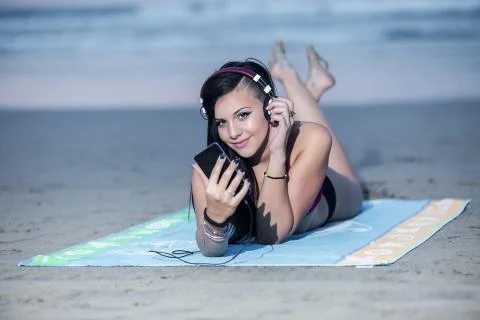 Alluring model posing in headphones on beach Stock Photos