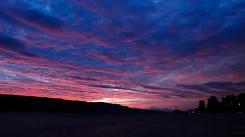 Alluring raspberry clouds in the sky at sunset Stock Photos