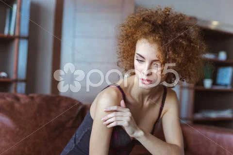 Alluring Sensual Woman Sitting On Sofa And Thinking
