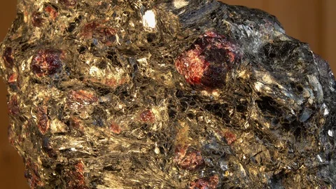Almandine-garnets Crystals interspersed in a massive piece of shale rock Video stock 129538139