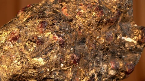 Almandine-garnets Crystals interspersed in a massive piece of shale rock Stock Footage 129821855