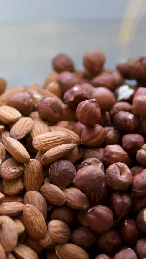 Almond and hazelnut Nuts falling glass bowl Nuts gently cascading into a jar of Stock Footage 302737093