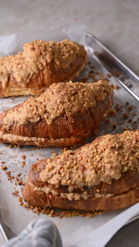 Almond croissants on baking tray put into oven and taken out after baking Stock Footage 337382811