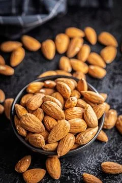 Almond kernel nuts in bowl on black table. Stock Photos