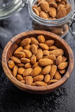 Almond kernel nuts in bowl on black table. Stock Photos