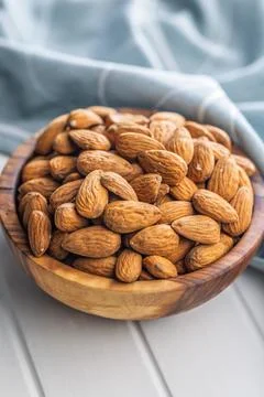Almond kernel nuts in bowl on white table. Stock Photos
