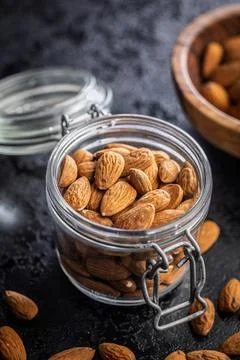 Almond kernel nuts in jar on black table. Stock Photos