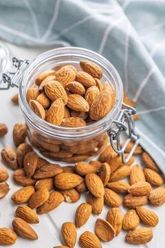 Almond kernel nuts in jar on white table. Stock Photos