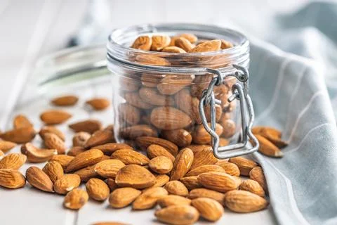 Almond kernel nuts in jar on white table. Stock Photos