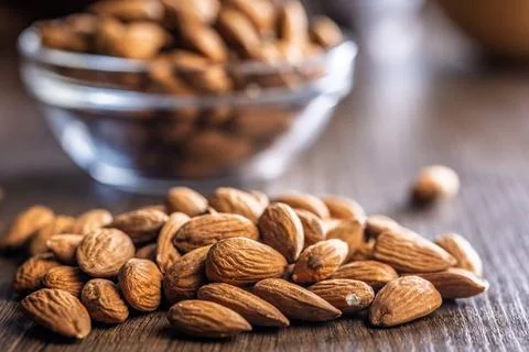 Almond kernel nuts on wooden table. Stock Photos