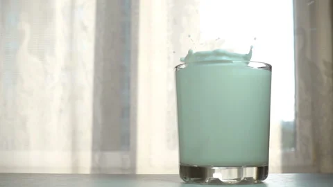 Almond nut falls in slow motion into a glass of milk Stock Footage 130507591