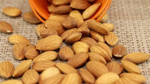 Almond nuts fell out of an orange metal bucket Stock Footage 123795003