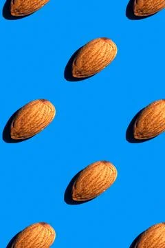 Almond pattern on blue background, colorful flat lay food texture top view Stock Photos