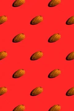 Almond pattern on red background, colorful flat lay food texture top view Stock Photos