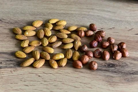 Almonds and peanuts lying on the table by the handful Stock Photos