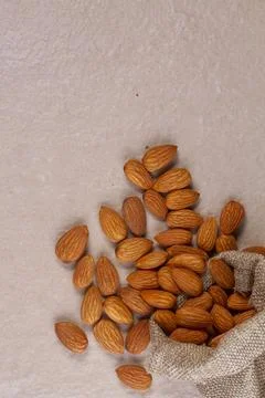 Almonds with in bag from sacking isolated on light background Stock Photos