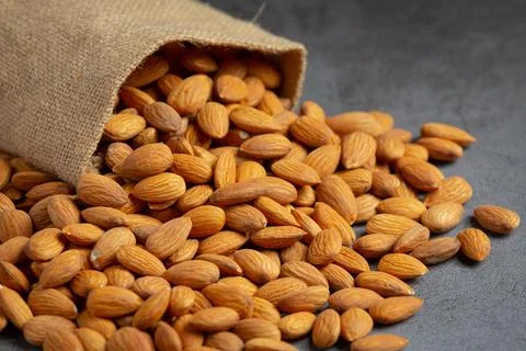 Almonds in bag from sackingl on dark background 写真素材
