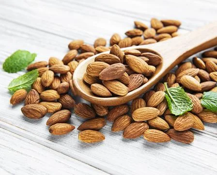 Almonds in brown spoon Stock Photos