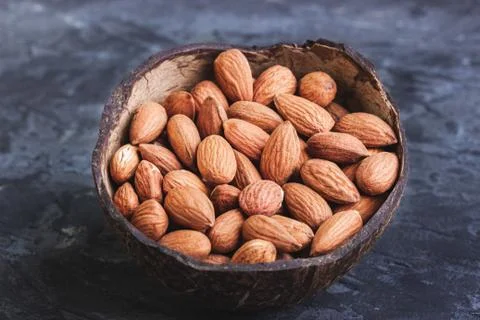 Almonds in coconut shells on a dark background Foto stock