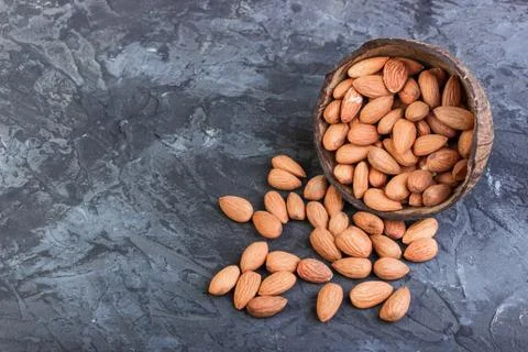Almonds in coconut shells on a dark background Foto stock