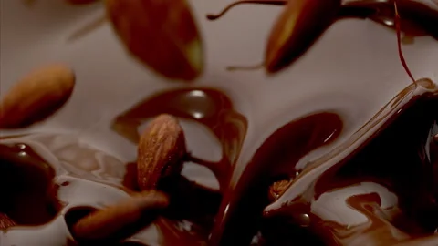 Almonds fall into the Melted Chocolate Super Slow Motion 1000fps. Stock Footage 265075594
