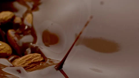 Almonds fall into the Melted Chocolate Super Slow Motion 1000fps. Stock Footage 265079538