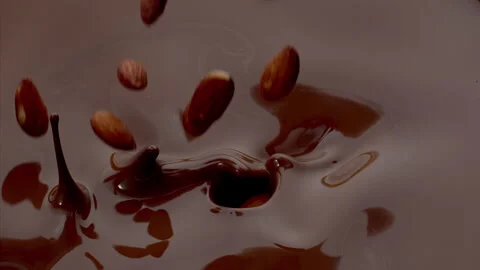 Almonds fall into the Melted Chocolate Super Slow Motion 1000fps. Stock Footage 281716568