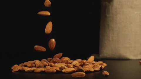An almonds fall in a pile on a table near a bag Stock Footage 59020012