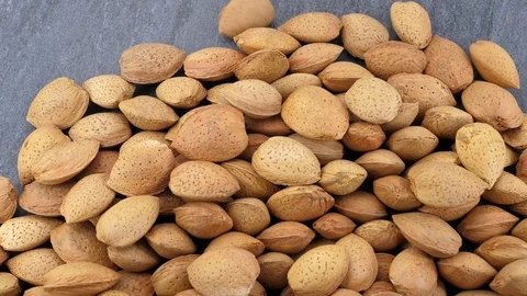 Almonds falling on grey stone background Vídeos de archivo 87710999