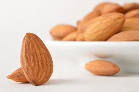 Almonds falling from the plate Stock Photos