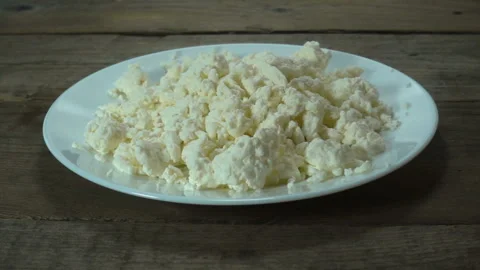 Almonds falling in a plate with raw cottage cheese in slow motion Video stock 130521503