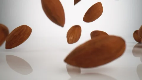 Almonds falling on surface. Slow Motion. Stock Footage 128768539