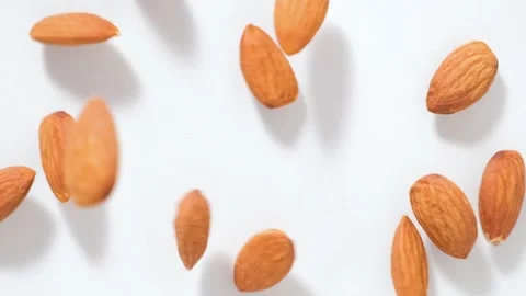 Almonds falling on white background. Slow motion video Stock Footage 150400926