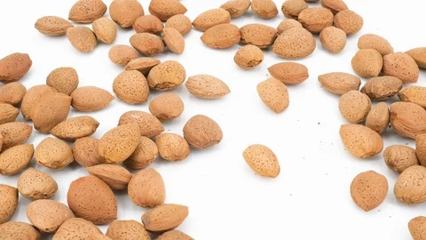 Almonds falling on white background, top view Vídeo Stock 87709194