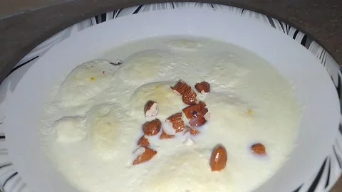 Almonds gently falling onto creamy ras malai in a bowl Stock Footage 316768684