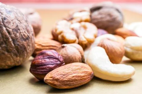 Almonds, Hazelnuts, Cashew Nuts and Whole Walnuts on Golden Background. Healt Foto stock